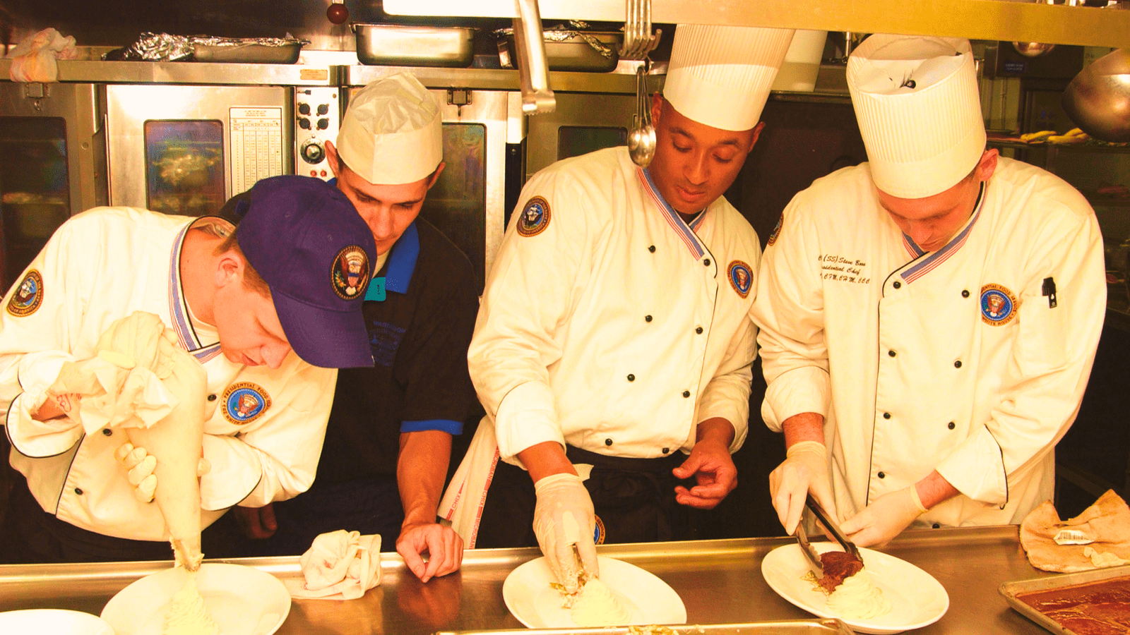 Four chefs plating up food in a commercial kitchen – Disability Access ...